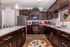Elegant modern kitchen with rich dark wood cabinetry, stainless steel appliances, and vibrant decorative accents, offering a stylish and functional space.