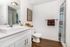 Bright and modern bathroom featuring a sleek white vanity, stylish blue shower curtain, and elegant decor accents.