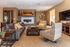 Elegant living room with plush sofas and patterned armchairs, featuring a modern fireplace and chic decor.