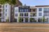 Modern apartment exterior at Mill Creek with sleek design, ample balconies, and lush greenery, offering urban living with style.