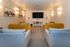 Chic apartment media room with vibrant yellow and gray seating, modern wall art, and a large flat-screen TV for entertainment.