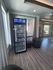 Modern lobby featuring a sleek vending machine stocked with snacks and drinks, complemented by stylish seating and large windows for natural light.