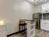 Charming kitchen with modern stainless steel appliances, elegant backsplash, and cozy dining nook with seating.