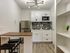 Modern kitchen with sleek white cabinets, stainless steel appliances, and chic lighting, perfect for a stylish apartment.