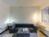 Cozy living room with a modern gray sectional sofa, elegant lighting, and a charming side table.