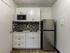 Modern compact kitchenette featuring sleek cabinetry, stylish backsplash, and stainless steel appliances.