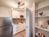 Chic modern kitchen with sleek cabinetry, stainless steel appliances, and stylish lighting, complemented by an elegant floating shelf display.