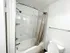 Modern bathroom with elegant marble-patterned walls, sleek bathtub, and stylish chrome fixtures.