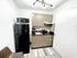 Modern compact kitchen featuring sleek wooden cabinets, black countertops, and contemporary lighting.