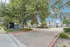 Entrance driveway with trees and Fusion at Rye Apartments signage in front of modern white apartment buildings in Houston TX.