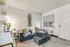 Modern furnished living room with gray sofa, soft lighting, and wall d&eacute;cor inside an apartment at Fusion at Rye in Houston TX.