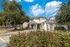 Exterior view of the leasing office at The Reserve at Rye 290 surrounded by landscaped greenery and parking access.