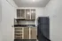 Studio kitchen with wood-finish cabinets, black countertop, and full-size refrigerator.
