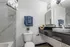 Studio bathroom with vanity sink, mirror, toilet, and shower tub.