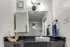 Studio bathroom vanity with sink, mirror, storage cabinet, and modern lighting.