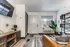 Studio living area with seating, TV console, front door, window, and shelving.