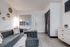 Studio living area with neutral flooring, window, and entry door at The Passages.