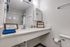 Bathroom with a wide vanity, large mirror, and tub with shower.