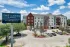 Exterior view of The Lanes @ Oslo apartment building with parking area and property sign.