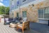 Outdoor seating area with chairs, sofas, and a fire pit.
