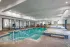 Indoor pool with seating and large windows.