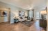 Modern living room boasting elegant decor, sleek wood flooring, and abundant natural light through large windows.