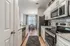 Modern kitchen with stainless steel appliances, elegant cabinetry, and inviting dining area with large window.