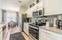 Bright and modern kitchen with stainless steel appliances, granite countertops, and elegant dining area overlooking large windows.