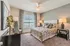 Inviting bedroom with chic decor, featuring plush bedding, elegant side lamps, and a large window for natural light.
