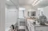 Elegant bathroom with dual sinks, stylish decor, and a modern bathtub, seamlessly connected to a cozy, well-lit bedroom.