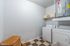 Bright and spacious laundry room featuring modern washer and dryer, sleek storage solutions, and checkerboard flooring for a stylish touch.
