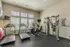 Bright and inviting fitness room equipped with modern treadmills, exercise bikes, and a multi-gym machine, perfect for a healthy lifestyle.