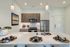 Modern kitchen with sleek cabinetry, stainless steel appliances, and stylish lighting, featuring a pristine island set for dining.