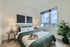 Inviting bedroom with elegant décor, natural light from large window, and modern accents, perfect for relaxation.