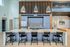 Sleek contemporary kitchen with elegant pendant lights, modern cabinetry, and a chic island with bar seating.