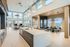 Spacious open-concept living area with large windows, modern kitchen island, and dining room, offering stunning panoramic views.