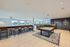 Spacious and modern game room featuring a sleek billiards table, chic bar seating, and large windows with scenic views.