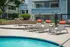 Inviting outdoor pool area with sun loungers and lush landscaping, perfect for relaxation in a modern apartment complex setting.
