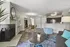 Charming open-concept living area with a cozy fireplace, modern kitchen, and stylish dining space. Features elegant decor with vibrant accents and a welcoming atmosphere.