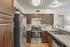 Modern kitchen featuring sleek stainless steel appliances, chic subway tile backsplash, and elegant wooden cabinetry.