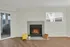 Inviting living space with a cozy fireplace, large windows, and stylish hardwood floors.