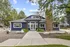 Charming modern home with striking blue exterior, inviting entrance, and lush greenery in a serene setting.