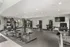 Modern fitness center with state-of-the-art exercise equipment, featuring cardio machines and weights in a spacious, well-lit room.