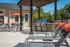 Luxurious outdoor patio featuring modern barbecue grills and comfortable sun loungers under a stylish pergola, perfect for relaxing and entertaining.