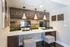Chic workspace with dual monitors, stylish wood paneling, and warm pendant lighting, perfect for productivity and comfort.