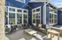 Charming outdoor patio with modern seating, vibrant blue siding, and string lights for a cozy ambiance.