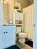 Chic and modern private  bathroom with elegant countertop, stylish storage, and lush greenery.