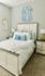 Large Spacious Charming bedroom with elegant decor, featuring a cozy bed, plush pillows, and stylish bedside tables against a serene gray backdrop.
