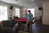 Spacious recreation room featuring a vibrant red pool table, cozy seating area, and large windows allowing natural light.