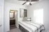 Cozy bedroom with stylish decor and modern en-suite bathroom, featuring elegant lighting and chic furnishings.